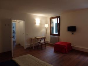 a room with a bed and a table and a window at Appartamento Goldoni in Venice