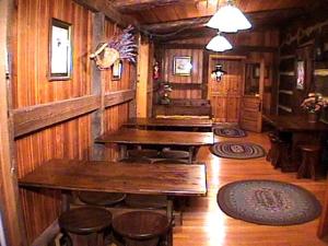 a dining room with tables and stools in a cabin at Rustic and Private Family Cabin Rental on Beech Mountain, North Carolina in Beech Mountain