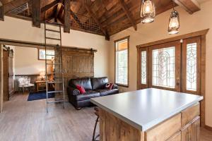 a living room with a couch and a table at Two-Bedroom Cabin Rental with Fully Equipped Kitchen near Fredericksburg, Texas in Quinlan