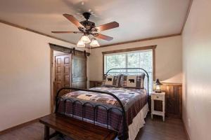 a bedroom with a bed and a ceiling fan at Two-Bedroom Cabin Rental with Fully Equipped Kitchen near Fredericksburg, Texas in Quinlan