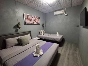 a room with two beds and a stuffed animal sitting on the bed at Paksina Hotel in Narathiwat +82 photos