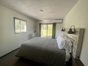 - une chambre avec un lit doté d'une couverture en damier et d'une fenêtre dans l'établissement Trendy and Spacious Cabin Surrounded by Nature in Rapid City, South Dakota, à Hill City