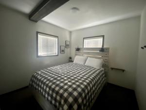 une chambre avec un lit avec une couverture à carreaux dans l'établissement Trendy and Spacious Cabin Surrounded by Nature in Rapid City, South Dakota, à Hill City