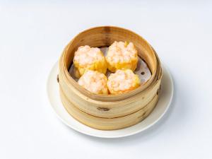 a wooden bowl filled with shrimp on a white plate at TRANSCENDER HOTEL Yokohama in Yokohama