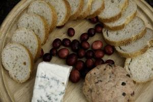 a plate of bread and grapes and a piece of cheese at Historic One-Room Cabin near Ocala National Forest in Central Florida in Fort McCoy