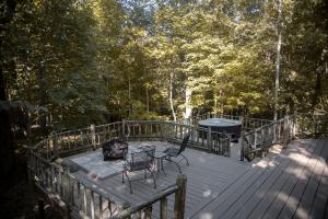 a deck with a grill and two chairs on it at Rustic Cozy Cabin with Hot-tub in Carbondale, Illinois in Etherton