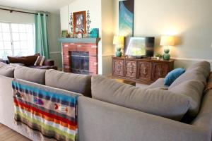 Pet Friendly Fantastic Secluded Cottage with Hot-tub in Rainbow, California في Rainbow: غرفة معيشة مع أريكة ومدفأة