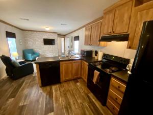 eine Küche mit Holzschränken und einem Herd mit Backofen in der Unterkunft Off-Grid Cottage with Nice Sights in Dunnellon, Florida in Dunnellon + 25 Fotos