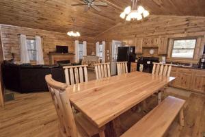a dining room with a wooden table in a cabin at Charming Log Cabin with a Fire Pit in the Woods near Lake Logan in Ohio in Cedar Grove
