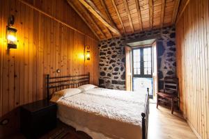a bedroom with a bed in a room with wooden walls at Villa 4 Seasons in São Roque do Pico