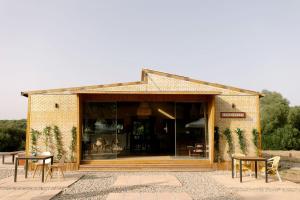 ein Gebäude mit Tischen und Stühlen davor in der Unterkunft Airstream Oasis: Unique Retreat near Andalucia's Best Beaches and Nature Haven! in El Soto