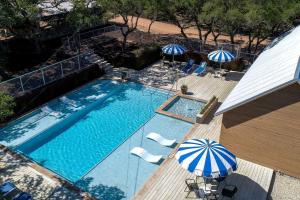 ドリッピング・スプリングスにあるClassically Southern Texas Hill Country Cabins for Weekend Getaways near Austinのスイミングプール(椅子、パラソル付)のオーバーヘッドビュー +9枚の写真