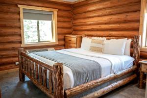 a bedroom with a bed in a log cabin at Spacious Luxury Cabin with Bunk Room & Nature Trail Access near Bonners Ferry, Idaho in Bonners Ferry