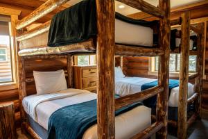 two bunk beds in a log cabin at Spacious Luxury Cabin with Bunk Room & Nature Trail Access near Bonners Ferry, Idaho in Bonners Ferry +9 photos