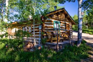 a log cabin in the woods with a porch at Rural Cabin Rental in Secluded Mountain Area in North Central Colorado in Columbine