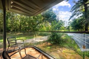 a screened in porch with two chairs and a window at Futuristic Pod Glamping Retreat with Pond Views in South Carolina in Saint Stephen