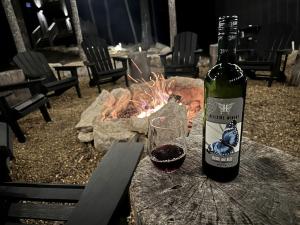 - une bouteille de vin assise sur une table à côté d'un feu dans l'établissement Luminous Cottage with Lofted Interior in Sevierville, Tennessee, à Dupont Springs