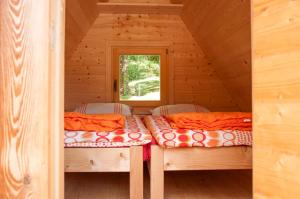 two beds in a log cabin with a window at Unique A-Frame Cabin Rentals for a Vacation near Bovec, Slovenia in Soča
