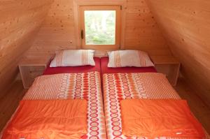 two beds in a small room with a window at Unique A-Frame Cabin Rentals for a Vacation near Bovec, Slovenia in Soča