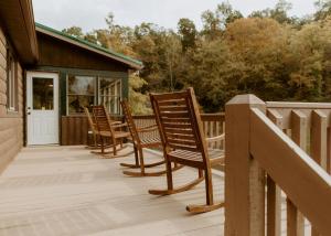 a row of chairs sitting on a deck at 16 Guests | Ponds | Hot Tub | Game Room | Trails in Sarahsville in Senecaville