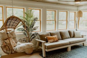 a living room with a couch and a swing at 16 Guests | Ponds | Hot Tub | Game Room | Trails in Sarahsville in Senecaville
