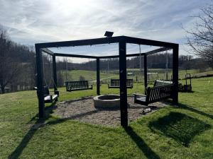 a group of benches sitting in a park at 16 Guests | Ponds | Hot Tub | Game Room | Trails in Sarahsville in Senecaville