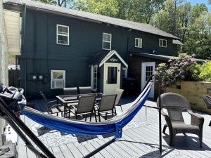 a hammock on a deck in front of a house at Hike & Ski Hideaway @ Lake Placid, NY in Lake Placid