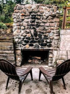 two chairs sitting in front of a stone fireplace at Hike & Ski Hideaway @ Lake Placid, NY in Lake Placid +20 photos