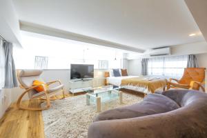 a living room with a couch and a tv at Hotel Estasia Ryogoku in Tokyo
