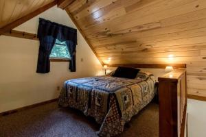 Un dormitorio con una cama en una habitación con techo de madera. en Secluded West Virginia Cabin Rental on the Edge of Monongahela National Forest, en Riverton