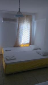 a bed in a room with a window and a bed sidx sidx sidx at Denizci Pension in Kaş