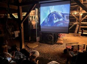 un grupo de personas sentadas frente a una gran pantalla en Cozy Hot Tub “Love Bus” near Augusta, Kentucky, en Brooksville