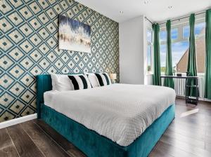 ein Schlafzimmer mit einem großen Bett und einer Wand in der Unterkunft Brand New Luxurious 3bed House in Northfleet