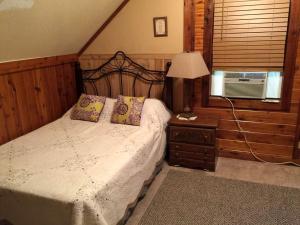 a bedroom with a bed and a lamp and a window at Peaceful and Secluded Lake Getaway in Guntersville, Alabama in Albertville