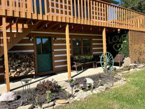 a house with a deck with a green door and a patio at Peaceful Cabin Perfect for Families in Lawrenceburg, Indiana in Aurora