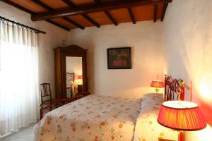 a bedroom with a bed with two lamps and a mirror at Casa Terra Rossa in Fauglia