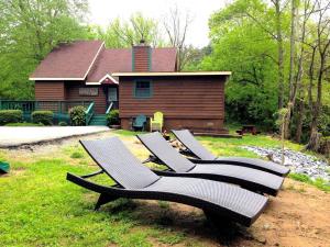 a group of chairs sitting in the grass in front of a house at Luxury Cabin Rental for a Family Getaway in Pigeon Forge, Tennessee in Waldens Creek