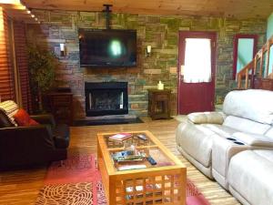 a living room with a couch and a fireplace at Luxury Cabin Rental for a Family Getaway in Pigeon Forge, Tennessee in Waldens Creek +19 photos
