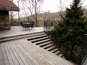 a wooden deck with a table and a tree at Fantastic Cabin Rental Perfect for a Family Vacation to Northwest Arkansas in Ponca