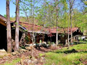 a log cabin in the woods next to some trees at Fantastic Cabin Rental Perfect for a Family Vacation to Northwest Arkansas in Ponca