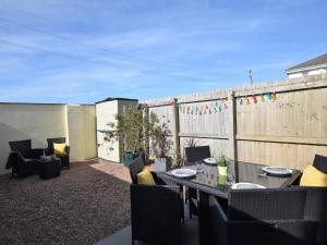 Un patio con mesa y sillas y una valla. en 3 Bed in Westward Ho 74354, en Westward Ho 7 fotos más
