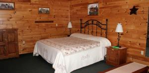 a bedroom with a bed and a wooden wall at Flintstone Vacation Rental for the Best Weekend Getaways in Maryland in Flintstone