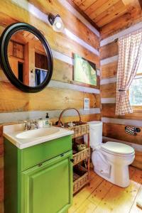 ein Badezimmer mit einem Waschbecken und einem WC in einem Blockhaus in der Unterkunft Beautiful Waterfront Cabin with Hot Tub near Winston-Salem, North Carolina in Elkin + 13 Fotos
