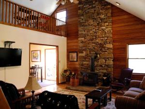 a living room with a fireplace and a stone wall at Spacious Mountain Cabin Rental with Wood Stoves near Hendersonville, North Carolina in Cedar Mountain