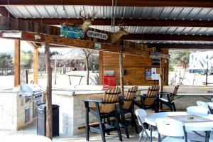a restaurant with tables and chairs on a patio at Perfect Texas Glamping in this Cozy Log Cabin Rental for 4 near Austin in Pipe Creek