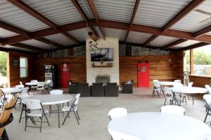 a group of tables and chairs in a building at Perfect Texas Glamping in this Cozy Log Cabin Rental for 4 near Austin in Pipe Creek +8 photos