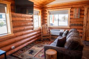 a living room in a log cabin with a couch at Rustic-Chic Log Cabin with King Bed & Kitchen | Bonners Ferry, Idaho Retreat in Bonners Ferry