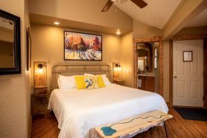 a bedroom with a large white bed with a painting on the wall at Rustic Camping Cabin near the Royal Gorge in Salida, Colorado in Monarch