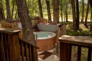 a bath tub sitting in the woods next to a tree at Rustic Camping Cabin near the Royal Gorge in Salida, Colorado in Monarch