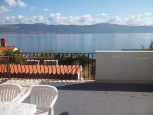 a table and chairs on a balcony with a view of the water at Apartments Viva Ciovo in Slatine